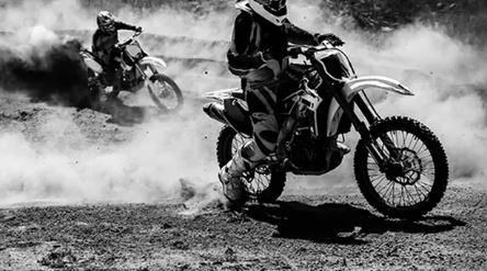 Motocross racer accelerating in dust track, Black and white, high contrast photo