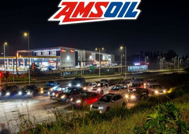 A row of cars parked at a traffic junction on the road.