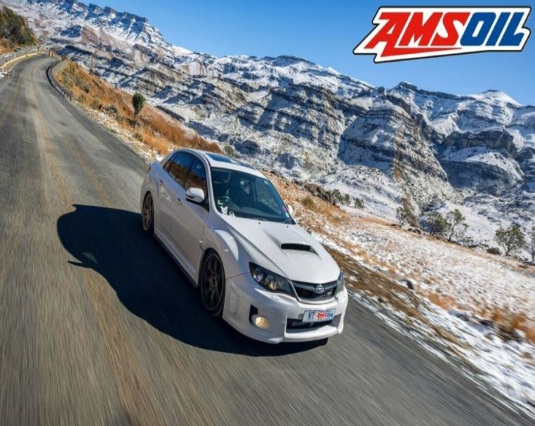 A car travelling on a mountain road covered in a layer of snow